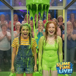 Two tween girls. One has her mouse-brown hair in two shoulder length braids. She has sharper facial features and a trapizoid headshape. She is wearing denim shortalls over a stripped yellow shirt. The other has wavy just-past-the-shoulders copper-ginger hair, mostly worn down and partly held back. She has soft facial features, hazel eyes and an oval face dotted with freckles. She is wearing tights and a spagetti strap white shirt. They are giggling in surprise.